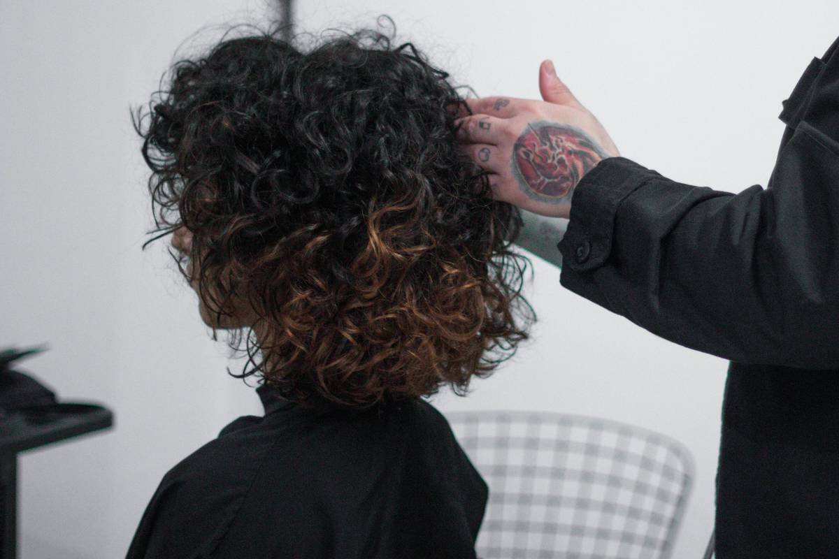 Before and after photos of client Maya showing frizzy, undefined hair transforming into soft, defined waves after using correct conditioner with texturizer