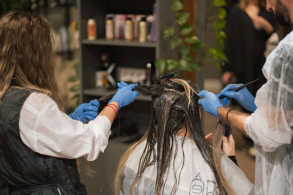 Woman applying targeted hair care solution to defined curls