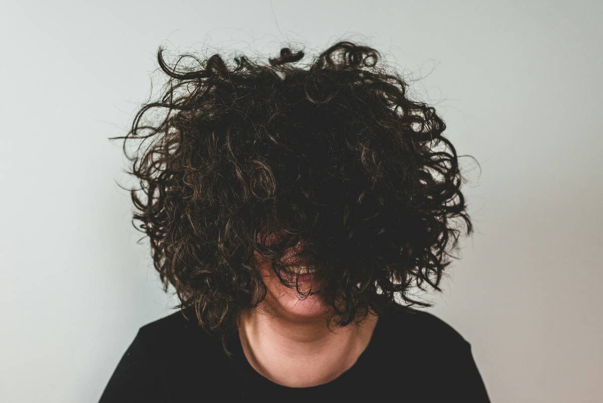 Close-up of healthy, defined curls enhanced by hair nourishing gel showing shine and bounce