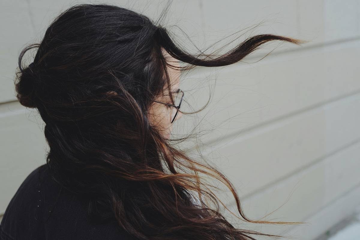 Close-up of hair strands lifted by volume hair mist showing natural separation and shine