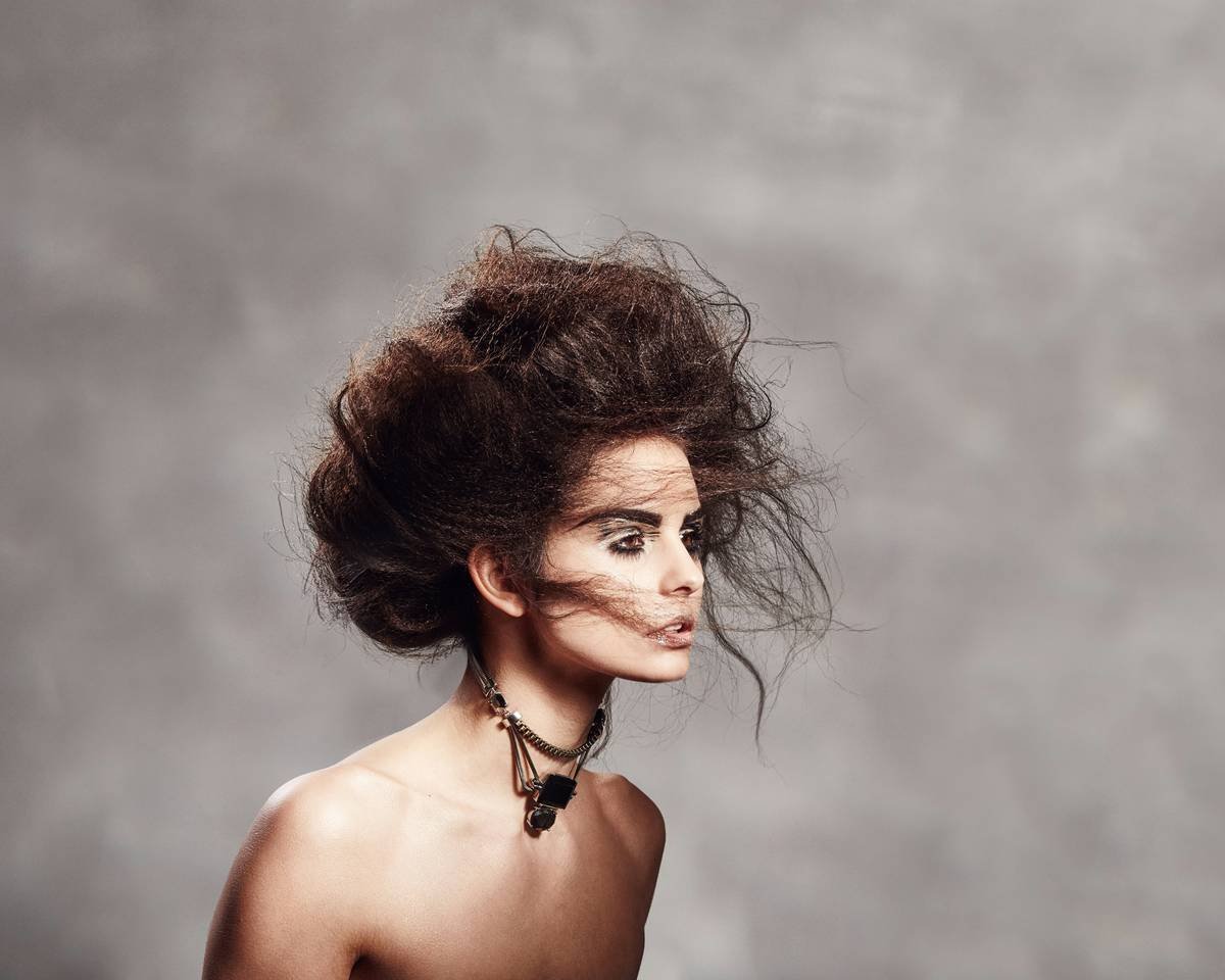 Woman applying styling mousse to damp hair for natural volume and texture